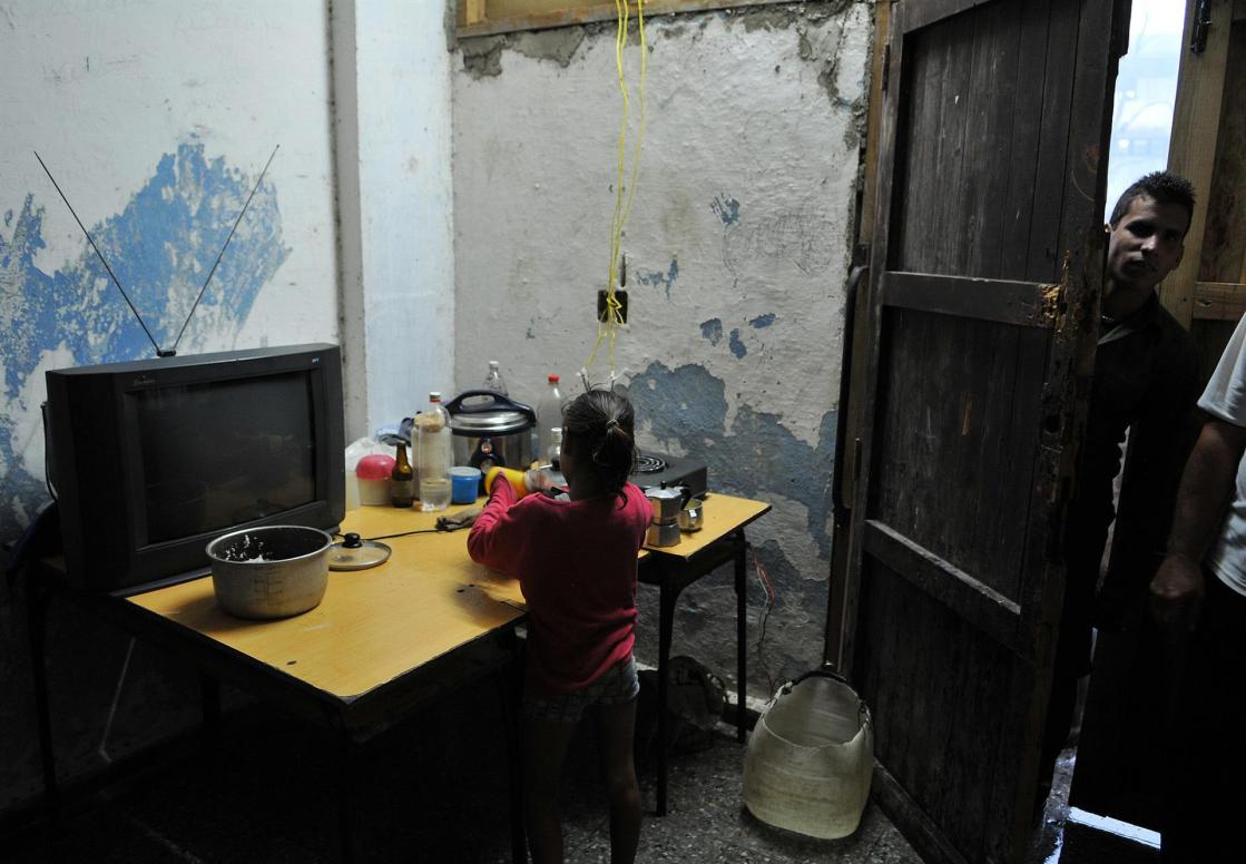 Fotografía de archivo fechada el 10 de septiembre de 2008 que muestra a una niña mientras lava platos en una improvisada cocina en el poblado José Martí, municipio de San Cristóbal, provincia de Pinar del Río (Cuba). EFE/Alejandro Ernesto
