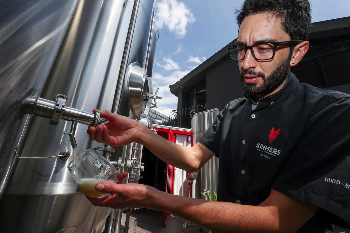 El gerente de producción de Sinners Micro Cervecería, Andrés Bermeo, sirve una muestra de la cerveza el 19 de agosto de 2022 en Quito (Ecuador). EFE/José Jácome