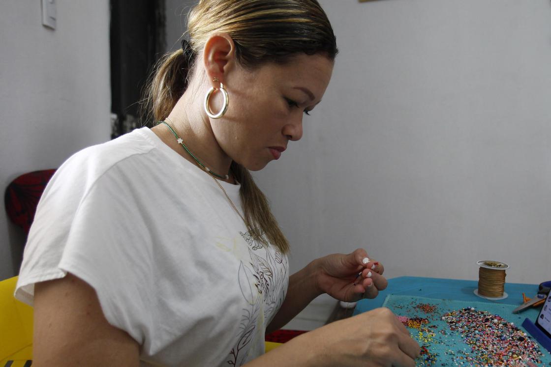 La emprendedora Natalia Vides, propietaria de Naty Accesorios, elabora pulseras el 17 de noviembre de 2022, en el departamento de Ovejas (Colombia). EFE/ Luis Eduardo Noriega A. 