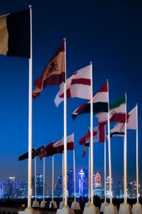 GRAF7720. DOHA, 08/11/2022.- Conservador, multicultural, acogedor y seguro. Así es Catar, un pequeño país de contrastes con menos de tres millones de personas de los que un 80% son extranjeros y que, en apenas unas semanas, acogerá el Mundial de fútbol, su gran baza para abrirse al mundo y demostrar su sorprendente evolución social, cultural y económica. En la imagen, banderas de los países participantes en el Mundial con el skyline de Doha al fondo. EFE/ Alberto Estévez