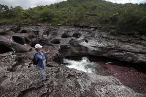 Fotografía que muestra a una turista mientras visita el río Caño Cristales, también llamado el "río de los siete colores", en zona rural de La Macarena, departamento del Meta (Colombia). Colombia buscará más inversión extranjera en España durante la Feria Internacional de Turismo (Fitur) de Madrid, que se llevará a cabo entre el 18 y 22 de enero, informaron este martes fuentes oficiales. EFE/ Luis Eduardo Noriega