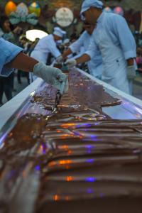 Fotografía cedida hoy por Visit Argentina que muestra a maestros chocolateros mientras trabajan en la elaboración de una inmensa chocolatina, como la que este año se espera que supere los 215 metros de largo en la Fiesta del Chocolate, que se celebrará del 6 al 9 de abril en San Carlos de Bariloche (Argentina). Bariloche, uno de los destinos turísticos más populares de Argentina, es, además, la capital nacional del chocolate debido a su reputada elaboración artesanal de dulces en base a derivados del cacao y que cada año son el centro de una popular fiesta donde chuparse los dedos es regla de etiqueta. EFE/ Visit Argentina /SOLO USO EDITORIAL /SOLO DISPONIBLE PARA ILUSTRAR LA NOTICIA QUE ACOMPAÑA (CRÉDITO OBLIGATORIO)