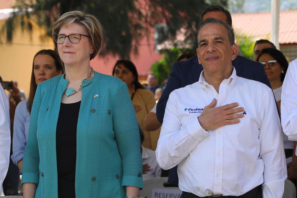 Laura Dogu (i), embajadora de los Estados Unidos en Honduras, junto a Juan Carlos Atala (d), del Grupo Financiero Ficohsa, asisten durante un evento público en el Centro de Educación Básica Esteban Mendoza, el 6 de junio de 2023, en Tegucigalpa (Honduras). EFE/Gustavo Amador