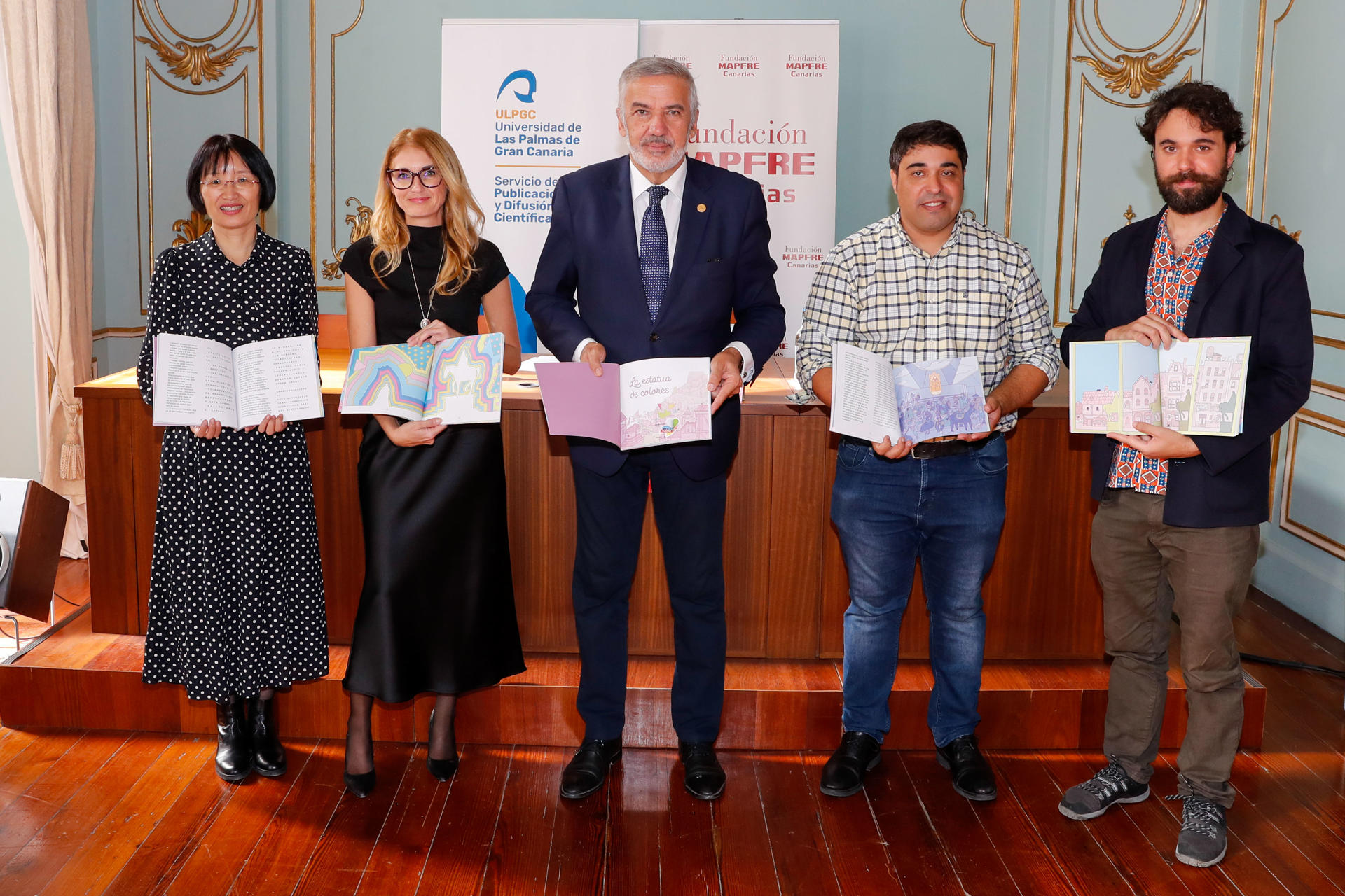 GRAFCAN2176. LAS PALMAS DE GRAN CANARIA, 13/12/2023.- La coordinadora de Actividades de la Fundación Mapfre Canarias, Laura Carvias (2i); el rector de la Universidad de Las Palmas de Gran Canaria, lluis Serra (c); el autor y el ilustrador del cuento solidario "La estatua de colores", los hermanos José Alberto (2d) y Jorge Luis Socorro (d); y la traductora de Chino Lili Wang (i), durante la presentación este miércoles de este relato ganador de la duodécima edición del certamen de cuentos solidarios que la ULPGC y la Fundación Mapfre Canarias convocan cada año, y cuyas ventas se donan siempre a una ONG. EFE/ Elvira Urquijo A.
