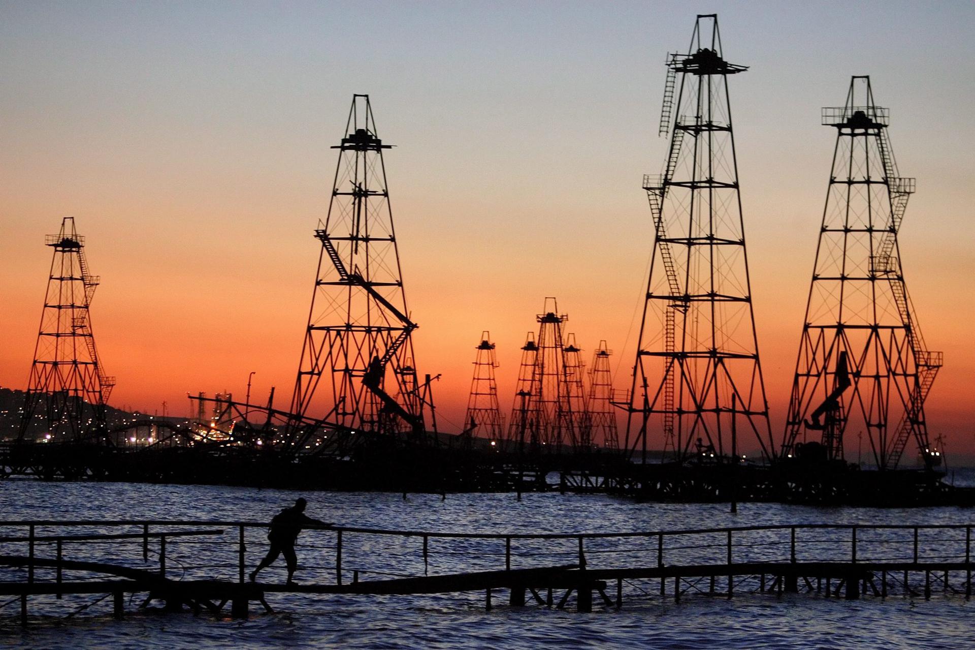 A worker walks in front of oil drilling towers in the Caspian Sea. EFE/Sergei Ilnitsky FILE