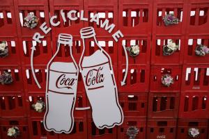 Fotografía de canastas y un logo de Coca-Cola con la palabra recíclame durante la inauguración de la primera planta de reciclaje de botellas del sistema Coca Cola Re-ciclar en la comuna de Lampa, Santiago (Chile). EFE/ Ailen Díaz