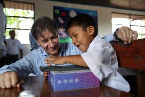 Fotografía del Director General de la Fundación Telefónica, Luis Prendes, junto a un niño observando una tableta en la institución educativa Miguel Grau, en la localidad de Miguel Grau, departamento de Ucayali (Perú).EFE/ Paolo Aguilar