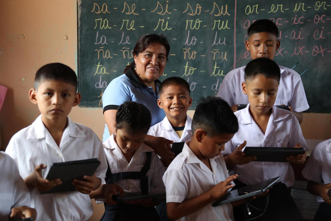 Fotografía de la profesora, René Romero, junto a varios niños manipulando tabletas en la institución educativa Miguel Grau, en la localidad de Miguel Grau, departamento de Ucayali (Perú).EFE/ Paolo Aguilar