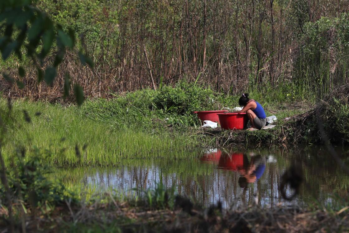 Una mujer lava ropa en la comunidad indígena de San Jacinto, en la región de Madre de Dios (Perú). EFE/Paolo Aguilar 