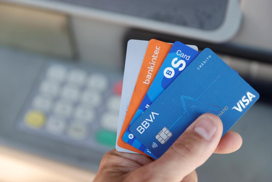 Una persona muestra las diferentes tarjetas que le permiten sacar dinero de un cajero, en Madrid. EFE/Emilio Naranjo