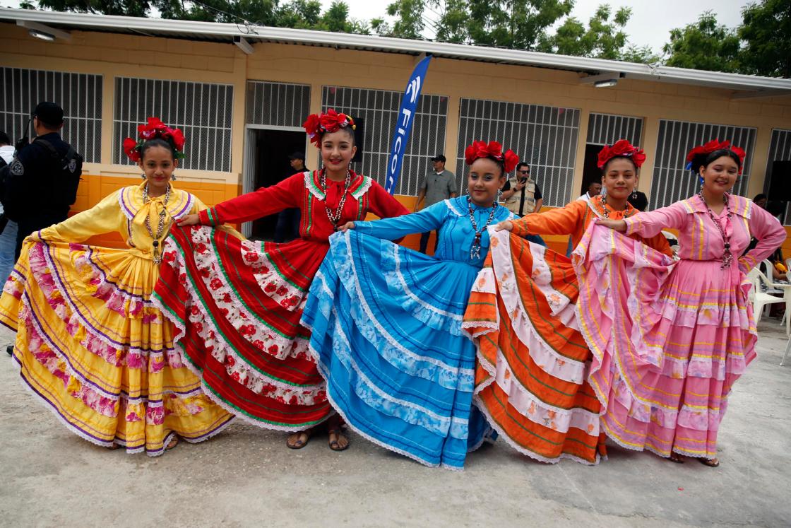 Estudiantes vestidas con trajes típicos hondureños posan antes de bailar en el Centro de Educación Básica Armando Montes en Juticalpa (Honduras). EFE/ Gustavo Amador 