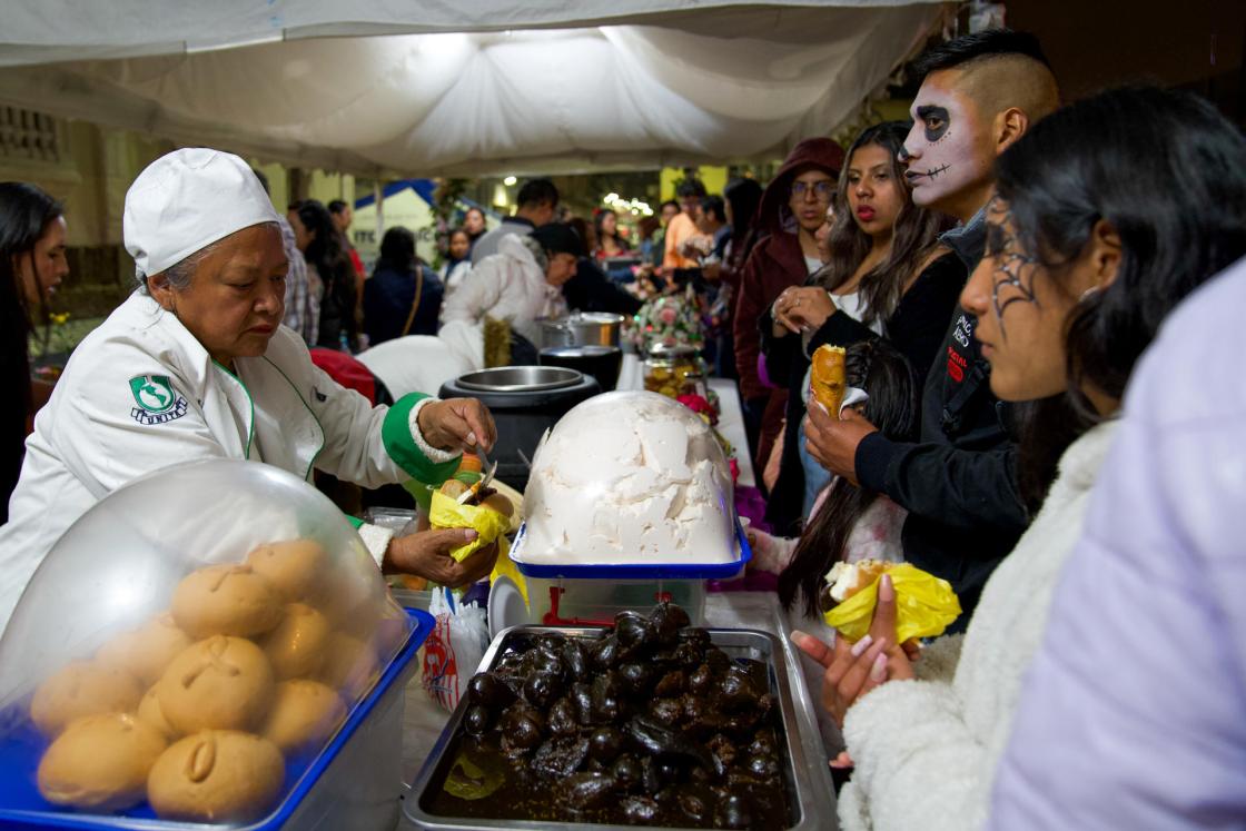 Personas disfrazadas consumen alimentos en Quito (Ecuador). EFE/Vicente Costales 