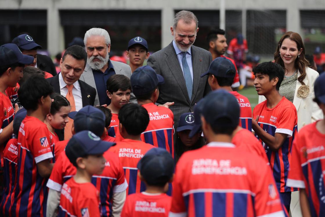 El rey Felipe VI (c) saluda a niños en la inauguración de una nueva escuela del Atlético de Madrid en Cuenca (Ecuador). EFE/ José Jácome