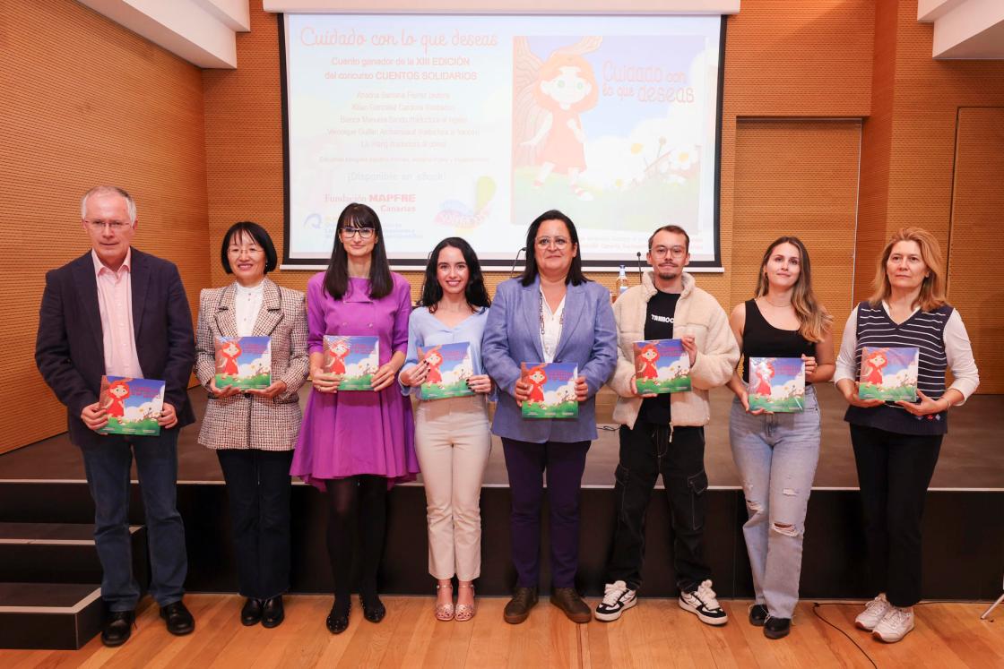 GRAFCAN9471. LAS PALMAS DE GRAN CANARIA, 18/12/2024.- La colección Cuentos Solidarios suma su decimotercer título, 'Cuidado con lo que deseas', que reflexiona sobre la infancia y la gestión de las tecnologías y cuya recaudación irá destinada a la Asociación Canaria Sociosanitaria Te Acompañamos. Ariadna Santana Fiérrez, autora del cuento ganador del concurso 'Cuentos Solidarios', un proyecto sociocultural promovido por la Fundación Mapfre Canarias, ha explicado en rueda de prensa que el libro narra la historia de Athenea, una niña de diez años que desea recibir por su cumpleaños su primer teléfono móvil, como el que ya tiene el resto de los compañeros de clase, porque considera que ya es una niña mayor.En la imagen, la directora de la Fundación Mapfre Guanarteme. Esther Martel (4d); la autora del cuento Ariadna Santana (4i), el director del Servicio de Publicaciones y Difusión Científica de la Universidad de Las Palmas de Gran Canaria (ULPGC) Antonio María Martín (i), el ilustrador Kilian González (3d); y las traductoras Bianca Manuela Sandu (3i), Véronique Guillén Archambault (d) y Lili Wang (2i) durante la presentación del cuento. EFE/ Elvira Urquijo A.