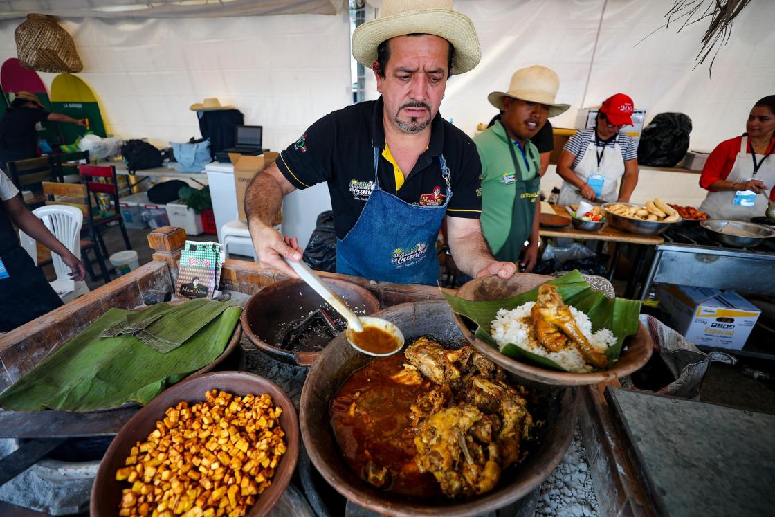 Un hombre sirve comida durante el Festival Gastronómico Sal Quiteña en Quito (Ecuador). EFE/ José Jácome 