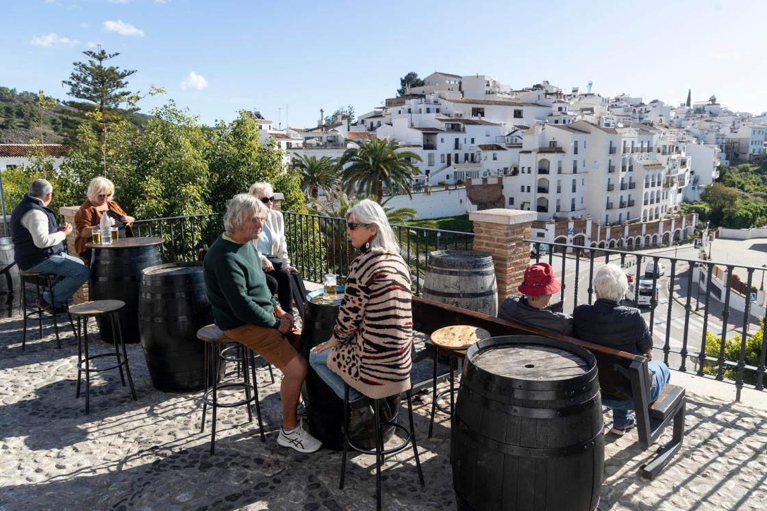 GRAFAND5600. FRIGILIANA (MÁLAGA), 18/12/2024.- Varios turistas descansan en uno de los bares de la localidad de Frigiliana (Málaga) uno de los municipios del interior de la Costa del Sol en los que ha crecido el interés por realizar rutas turísticas que cuentan con el aliciente de la gastronomía y han impulsado la venta de productos artesanales y de proximidad. EFE/Daniel Pérez