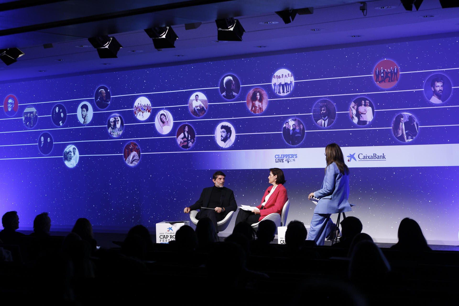 GRAFCAT5018. BARCELONA (ESPAÑA), 07/03/2025.- La directora de Comunicación y Relaciones Institucionales de CaixaBank Mª Luisa Martínez (c) , el presidente del Grupo Clipper y director del Festival de Cap Roig, Juli Guiu (i), durante la presentación este viernes de la programación de la 25 edición del Cap Roig Festival, uno de los principales ciclos musicales del verano en Cataluña, que llevará al jardín botánico de Calella de Palafrugell a destacados artistas nacionales e internacionales, en la que han anunciado que el cantante argentino Fito Páez, el británico James Blunt, las bandas escocesas Simple Minds y Franz Ferdinand o el galés Tom Jones figuran en la programación del Cap Roig Festival de este año, en el que celebra su 25 aniversario.EFE/ Quique García