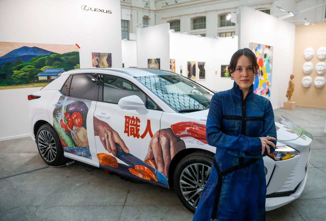 MADRID, 06/03/2025.- La artista vallisoletana Marta de la Fuente posa junto a su obra "Itadak Imasu", que permanece expusta este miércoles en el Stand de Lexus en la Feria de Arte "ART Madrid" en la Galeria de los Cristales del ayuntamiento de Madrid. EFE/David Fernández
