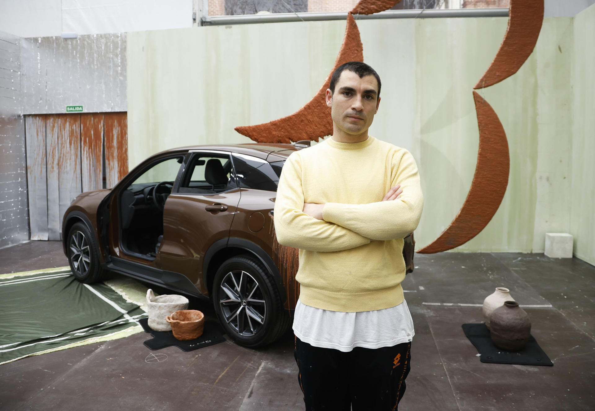 MADRID, 07/03/2025.- El artista Andrés Izquierdo posa junto a su obra "Reflejos de Silencio", una intervención sobre un vehículo Lexus, en el estand de la marca, en la feria de arte Art Fair, en las instalaciones de Matadero, Madrid, este viernes. EFE/David Fernández