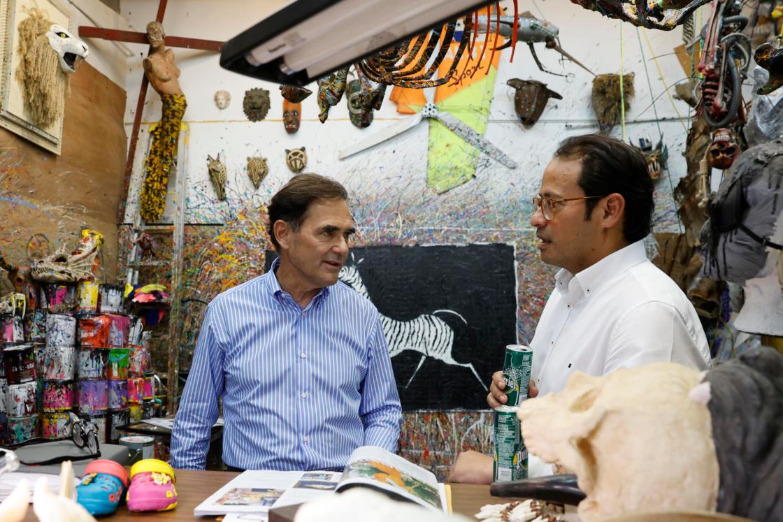 Fotografía del 9 de mayo de 2025 del artista panameño Eduardo Navarro (i) hablando con el director ejecutivo de 'Costa del Este News', Cristhian Flórez, en su taller en Ciudad de Panamá (Panamá). EFE/ Bienvenido Velasco