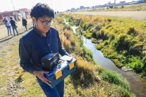 El estudiante José Felix Sarmiento prueba un dispositivo diseñado para medir de forma rápida y precisa los niveles de contaminación en el agua este miércoles, en Viacha (Bolívia). EFE/ Gabriel Márquez