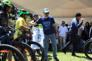 Fotografía del alcalde de Quito, Pabel Muñoz (c), saludando a un ciclista durante un recorrido en Yunguilla (Ecuador). EFE/ José Jácome