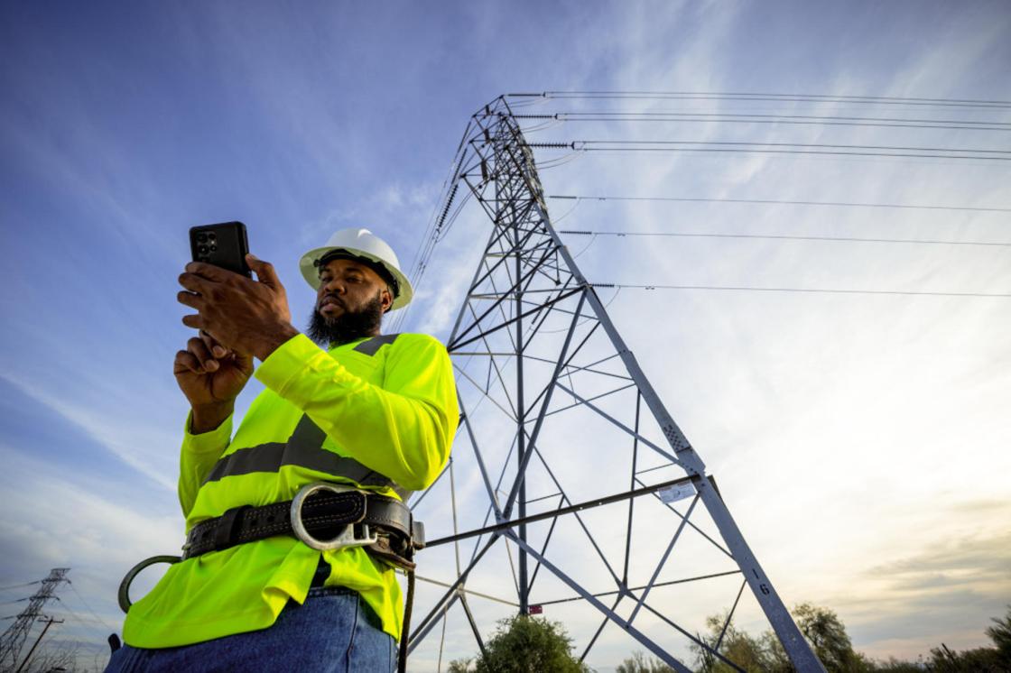 Fotografía sin fecha específica de toma cedida por T-Mobile que muestra a una persona observando su teléfono frente a una torre eléctrica en Estados Unidos. EFE/ T-mobile /SOLO USO EDITORIAL/NO VENTAS/ SOLO DISPONIBLE PARA ILUSTRAR LA NOTICIA QUE ACOMPAÑA (CRÉDITO OBLIGATORIO)