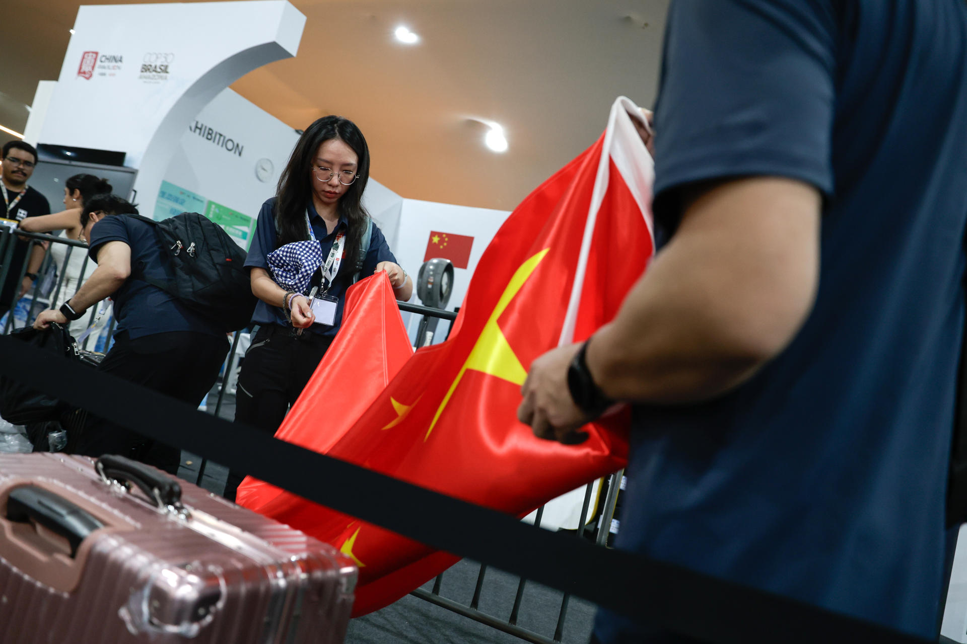 Integrantes de la delegación de China desmontan el pabellón de su país este viernes, mientras los demás pabellones permanecen cerrados tras un incendio en la Blue Zone de la COP30, en Belém (Brasil). EFE/ Fraga Alves