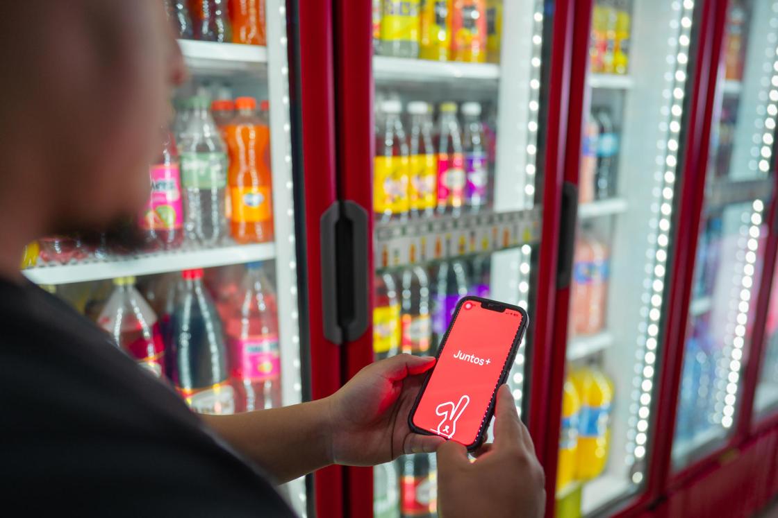 Fotografía del que muestra a una persona sosteniendo un teléfono con la aplicación Juntos + en su pantalla, en Ciudad de México (México). EFE/ Coca-cola Femsa /SOLO USO EDITORIAL/ NO VENTAS/ SOLO DISPONIBLE PARA ILUSTRAR LA NOTICIA QUE ACOMPAÑA (CRÉDITO OBLIGATORIO)