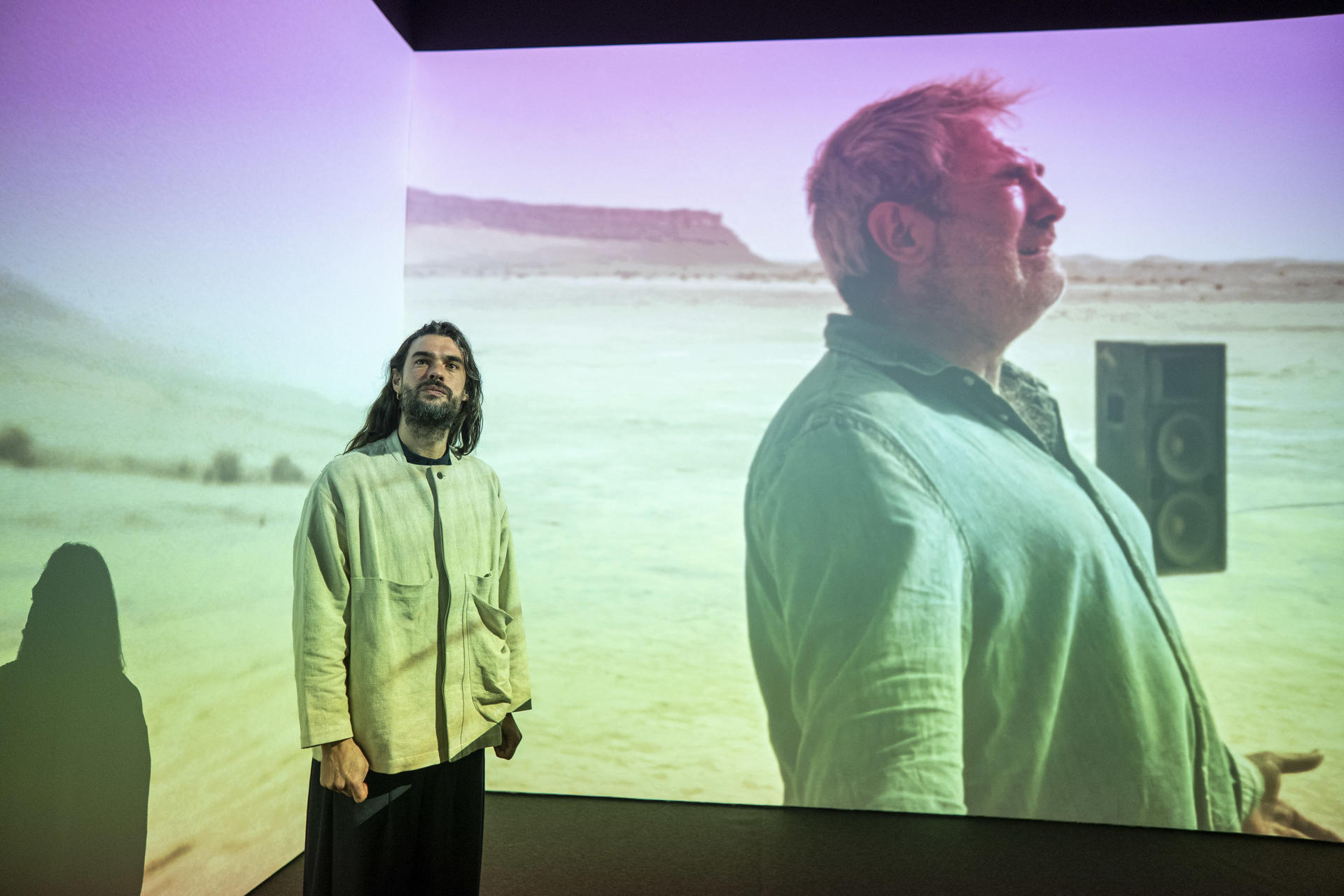 MADRID, 16/12/2025.- El cineasta gallego Oliver Laxe, ante la instalación 'Oliver Laxe, HU/هُوَ. Bailad como si nadie os viera', parte de la investigación y de las grabaciones de la película Sirāt, Gran Premio del Jurado en Cannes, 2025, durante la presentación este martes en el Museo de Arte Reina Sofía de dicha instalación, junto con una retrospectiva de la filmografía de Laxe y una carta blanca con tres películas escogidas por el autor. EFE/ Fernando Villar