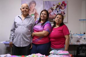 Fotografía de la migrante venezolana María Dorta (c) posando junto a sus padres durante una entrevista con EFE en Lima (Perú). EFE/ Paolo Aguilar