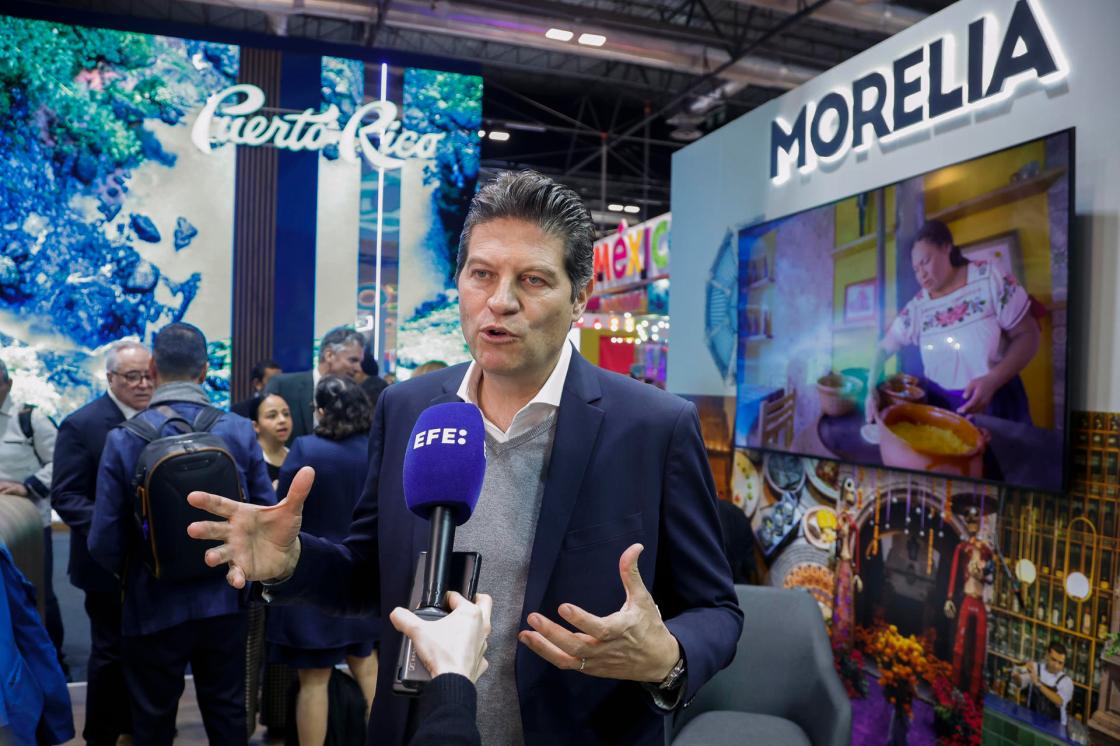 El alcalde de la ciudad mexicana de Morelia, Alfonso Martínez (c), atiende a EFE durante la jornada inaugural de la feria internacional de Turismos Fitur 2026, en las instalaciones de Ifema, este miércoles en Madrid. EFE/David Fernández