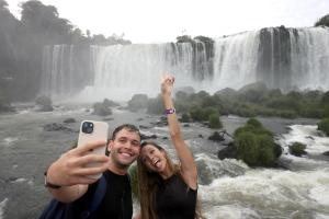 Fotografía de archivo que muestra a dos turistas tomandose una foto en las Cataratas de Iguazú, en el Parque Nacional de Iguazú en Foz de Iguazú (Brasil). EFE/ Juan Pablo Pino/ARCHIVO