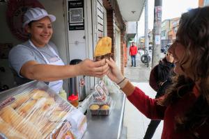 Fotografía del 23 de febrero de 2026 que muestra a la empresaria venezolana residente en Colombia María Félix Herrera vendiendo productos de su panadería en Bogotá (Colombia). EFE/ Carlos Ortega