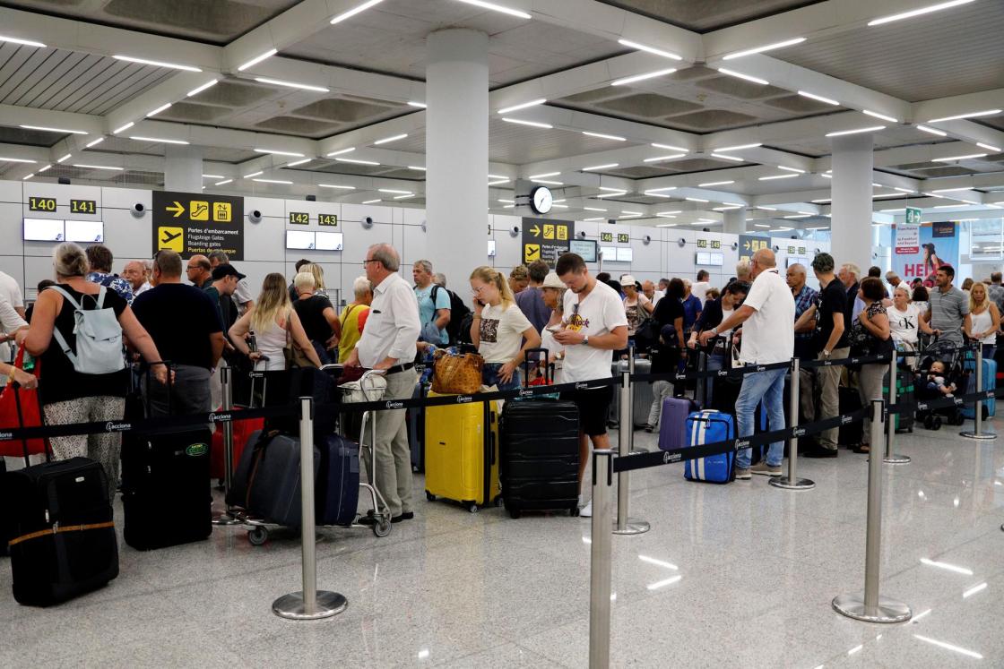 Varios turistas esperan para poder embarcar en sus vuelos en el aeropuerto de Palma de Mallorca.EFE/ Cati Cladera