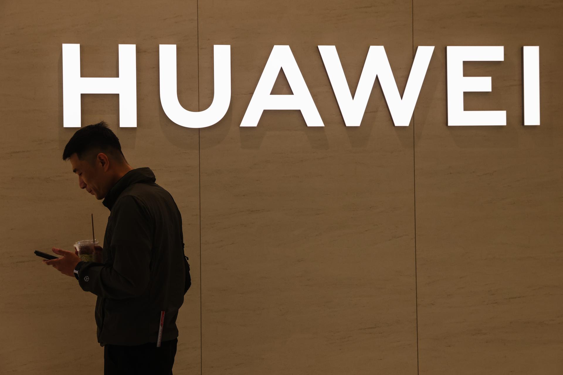 Un hombre utiliza su smartphone cerca de una tienda de Huawei en un centro comercial de Pekín, China, en una imagen de archivo. EFE/EPA/WU HAO
